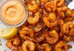 Crispy air fryer shrimp served on a plate with dipping sauce