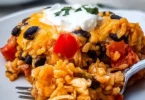 Cheesy chicken taco casserole topped with black beans and melted cheese