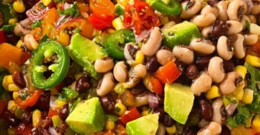A bowl of colorful cowboy caviar with black beans, corn, and tomatoes