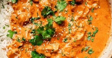 Crockpot Butter Chicken ready to serve with rice and garnished with cilantro