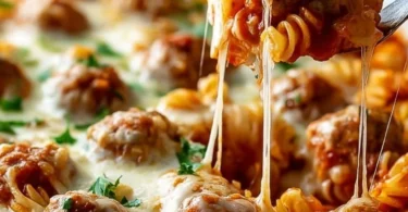 Delicious Dump and Bake Meatball Casserole topped with cheese and herbs.