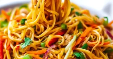 Plate of easy Thai noodles garnished with fresh vegetables and herbs.