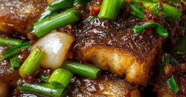 Delicious Ginger Onion Fried Sea Bass garnished with fresh herbs