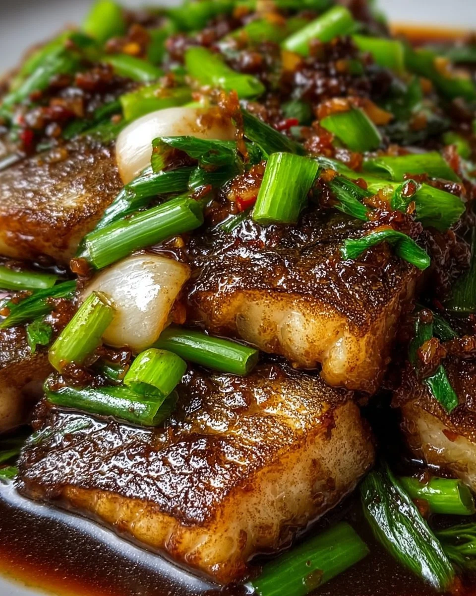Delicious Ginger Onion Fried Sea Bass garnished with fresh herbs