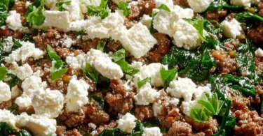 Ground beef and spinach skillet topped with feta cheese in a pan