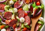 Colorful Italian salad with fresh vegetables, olives, and cheese.