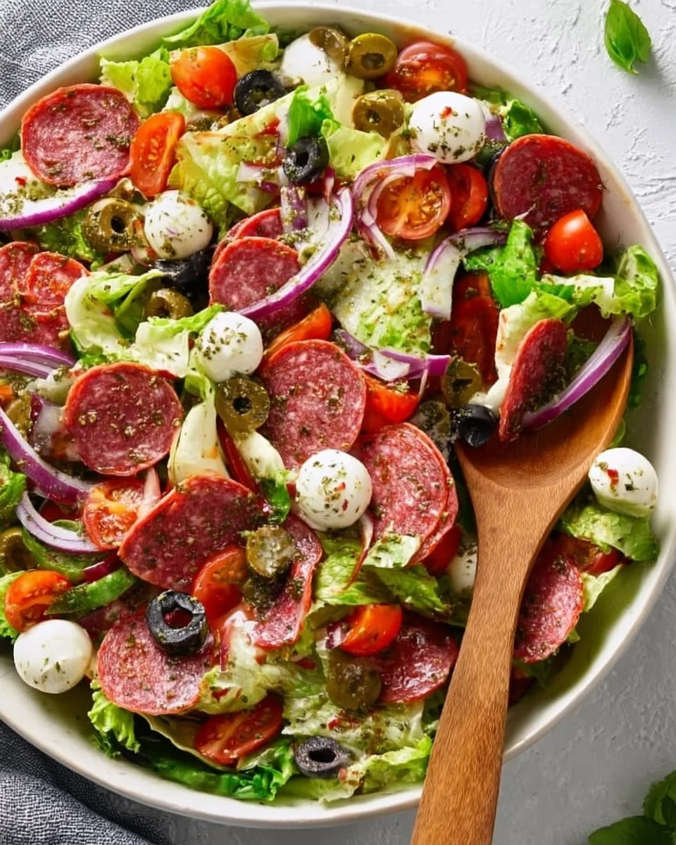 Colorful Italian salad with fresh vegetables, olives, and cheese.