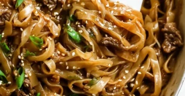 Plate of Mongolian Beef and Noodles garnished with green onions