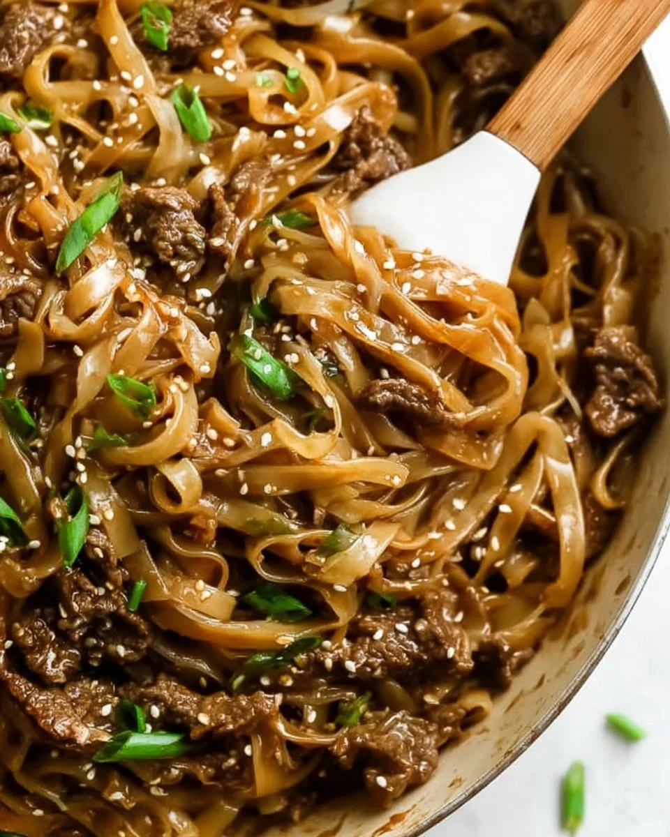 Plate of Mongolian Beef and Noodles garnished with green onions