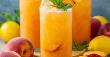 Glass of refreshing Peach Lemonade with slices of peach and lemon
