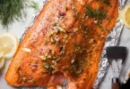 Plate of delicious smoked salmon garnished with herbs and lemon slices
